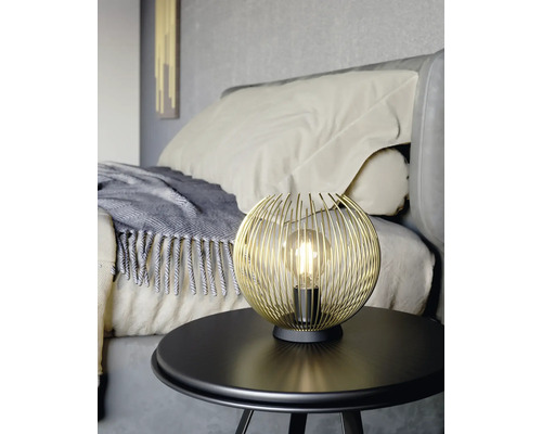 Zlatá drôtená guľová lampa na stole v spálni