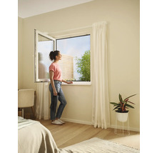 Žena pri otvorenom okne so sieťou proti hmyzu v spálni