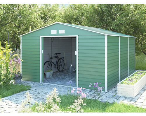 Zelený kovový záhradný domček so sedlovou strechou a posuvnými dverami v záhrade, vo vnútri s uloženým bicyklom a náradím.