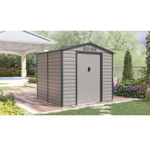 Kovový záhradný domček so sedlovou strechou a dvojkrídlovými dverami na drevenej terase vo svetlej, upratanej záhrade.