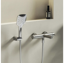 Moderná chrómová sprchová súprava pozostávajúca z hranatej ručnej sprchy v nástennom držiaku a valcovej sprchovej batérie so sprchovou hadicou.