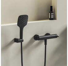 Sprchový set v matnej čiernej farbe s hranatou ručnou sprchou a valcovou termostatickou batériou na montáž na stenu.