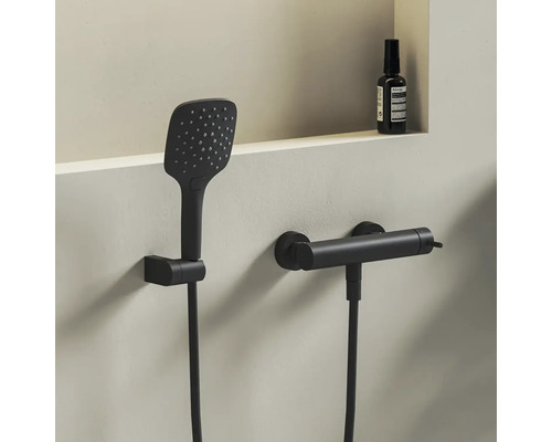 Sprchový set v matnej čiernej farbe s hranatou ručnou sprchou a valcovou termostatickou batériou na montáž na stenu.