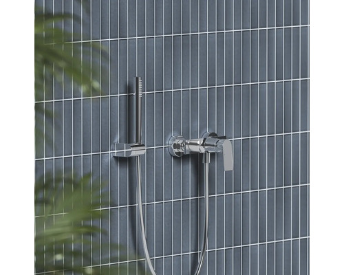 Chrómová páková vaňová batéria s tyčovou ručnou sprchou na moderne obloženej stene.