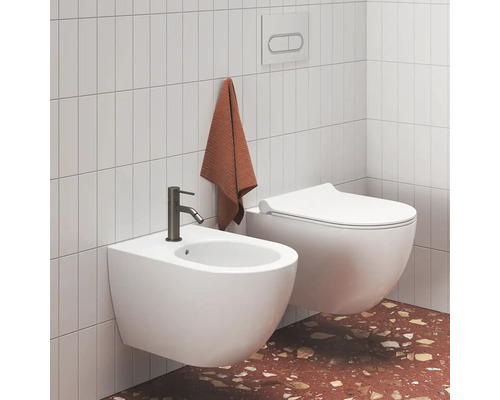 Svetlá moderná kúpeľňa so závesným bidetom s tmavou batériou a závesným WC pri obložených stenách a terazzovej podlahe.