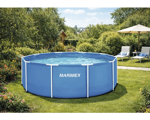 Okrúhly modrý nadzemný bazén s bielou rúrkovou konštrukciou Marimex na slnečnej záhrade s trávnikom, kvetmi a lehátkami.
