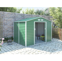 Zelený kovový záhradný domček so sedlovou strechou a posuvnými dverami na dláždenej terase pri tehlovom múre.