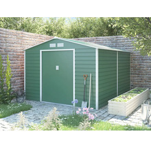 Zelený kovový záhradný domček so sedlovou strechou a bielym rámom v záhrade pred tehlovou stenou.