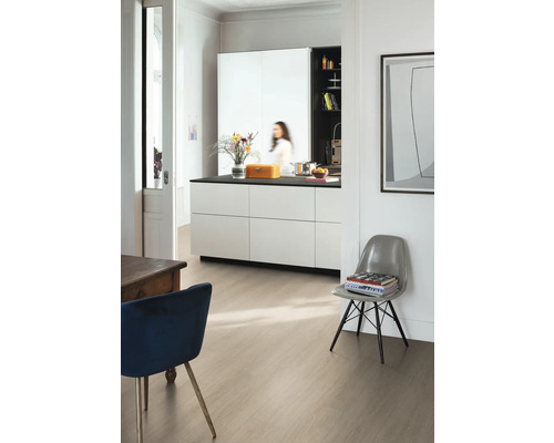 Moderná svetlá izba s laminátovou podlahou v svetlom dekore dreva, bielym kuchynským ostrovčekom s čiernou pracovnou doskou a dizajnovými stoličkami.