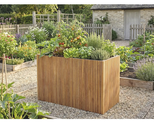 Vysoký vyvýšený záhon z drevených lamiel s paradajkami a bylinkami vo svetlej, usporiadanej záhrade so štrkovými cestami.