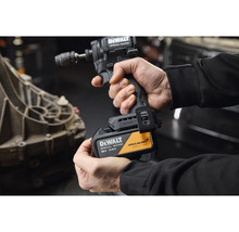 Osoba drží rázový uťahovák DeWalt Special Edition s 18 voltovým 4 ampérhodinovým akumulátorom, DeWalt Logo a McLaren Formula 1 Team Logo.