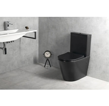 Moderná kúpeľňa s čiernym stojacim WC s nádržkou, bielym nástenným umývadlom s chrómovou batériou a sivou dlažbou v betónovom vzhľade.