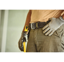 Kožený pracovný opasok s Stanley Logo na osobe v pracovnom odeve s rukavicami a náradím.