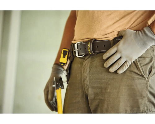 Kožený pracovný opasok s Stanley Logo na osobe v pracovnom odeve s rukavicami a náradím.