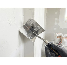 Rohová stierka Maurerlob pri nanášaní stierky do vnútorného rohu.