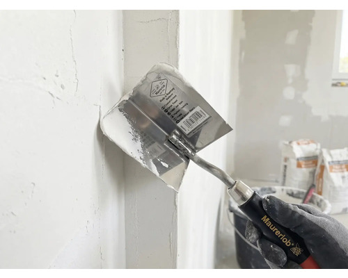 Rohová stierka Maurerlob pri nanášaní stierky do vnútorného rohu.