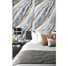 Moderná spálňa so stenou vo vzhľade mramoru, tmavou posteľou a nočným stolíkom s čiernou stolovou lampou.