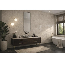 Moderná kúpeľňa s obkladom s mramorovým vzhľadom, tmavou skrinkou pod umývadlo, vzorovaným umývadlom, vysokým oválnym zrkadlom a voľne stojacou vaňou.