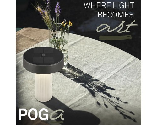 Solárna stolná lampa Poga s drážkovaným podstavcom na prestretom záhradnom stole vedľa vázy s kvetmi.