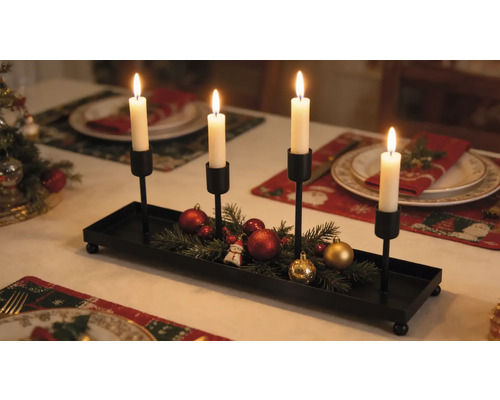 Adventný svietnik z čierneho kovu so štyrmi držiakmi na sviečky, zdobený jedľovou čečinou a vianočnými guľami na slávnostne prestretom stole.