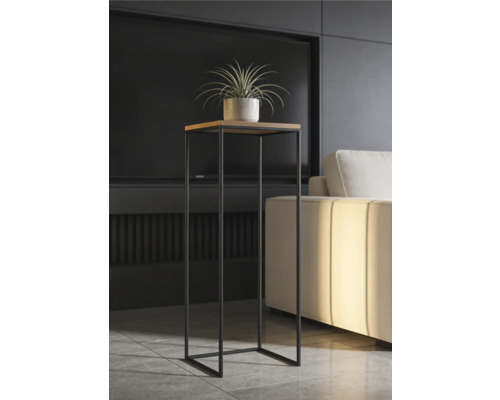 Moderný vysoký stojan na rastliny so štvorcovou drevenou doskou a čiernym kovovým rámom vo svetlej obývačke vedľa pohovky.