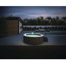 Nafukovacia vírivka Intex v tmavom drevenom dekore na modernej terase vedľa bazéna za súmraku s vonkajším nábytkom v pozadí.