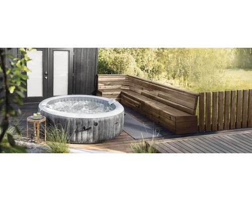 Nafukovacia vírivka Intex okrúhleho tvaru s dreveným dekorom na drevenej terase vedľa drevenej rohovej lavice.