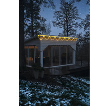 LED svetelný dážď s teplým bielym svetlom na modernom záhradnom domčeku v zimnom nočnom prostredí.