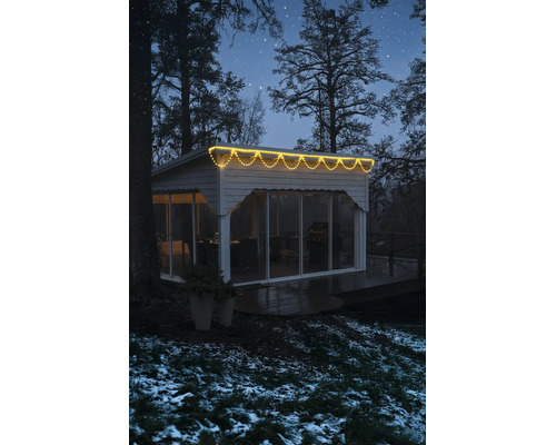 LED svetelný dážď s teplým bielym svetlom na modernom záhradnom domčeku v zimnom nočnom prostredí.