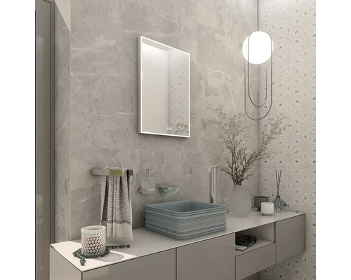 Moderná kúpeľňa s obkladmi v mramorovom vzhľade, hranatým umývadlom na dosku, minimalistickou skrinkou a osvetleným zrkadlom.