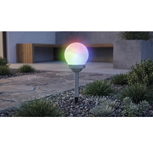 Solárne záhradné guľové svietidlo s viacfarebným RGB osvetlením, na zapichovacom hrote v štrkovom záhone s rastlinami.