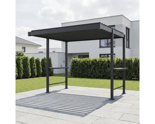 Moderná tmavá kovová pergola s lamelovou strechou na dláždenej terase v záhrade pred živým plotom a rodinným domom.