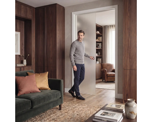 Moderná obývacia izba s matnými sklenenými posuvnými dverami, tmavými drevenými skriňami a zelenou zamatovou pohovkou.