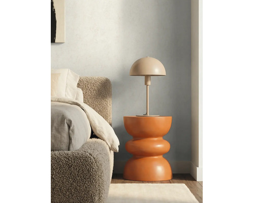 Stolná lampa v tvare huby na modernom sochárskom prístavnom stolíku vedľa postele s textúrovaným čelom.