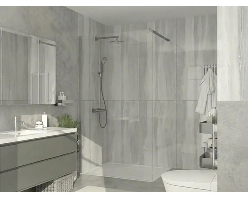 Moderný sprchovací kút walk-in so sklenenou stenou, chrómovým sprchovým systémom, plochou vaničkou a obkladom vo svetlej kúpeľni.