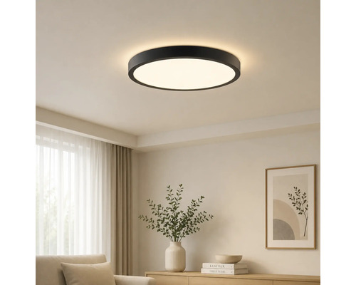 Moderné okrúhle stropné LED svietidlo s čiernym rámom vo svetlej obývacej izbe.