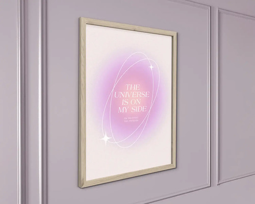 Zarámovaný obraz na stenu s nápisom THE UNIVERSE IS ON MY SIDE na abstraktnom pozadí, v svetlom drevenom ráme na stene.