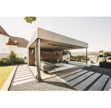 Moderná, svetlá kovová pergola s drevenou lamelovou stenou, závesmi a lounge nábytkom na drevenej terase v záhrade.