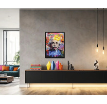 Svetlá, moderná obývačka s rámovaným pop-art obrazom Alberta Einsteina nad čiernou komodou s farebnými vázami.