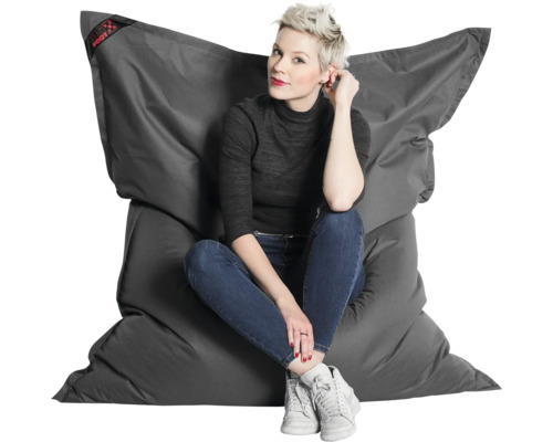 Žena sedí na veľkom, antracitovom sedacom vaku Big Foot z odolného materiálu.