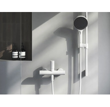 Moderný minimalistický sprchový set s ručnou sprchou na sprchovej tyči a sprchovou batériou vo svetlej, elegantnej kúpeľni.