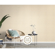 Vliesová tapeta s tehlovým vzorom v obývačke s ratanovým kreslom a príručným stolíkom.
