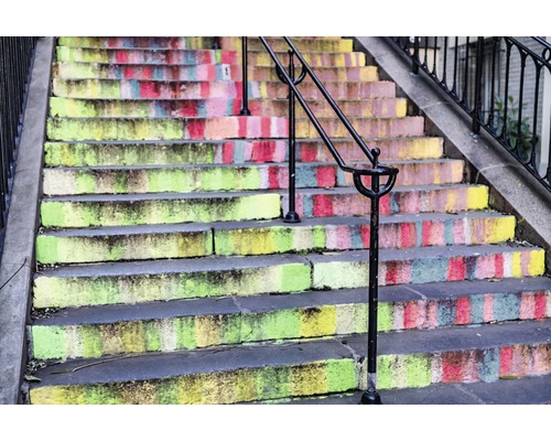 Schodisko s farebnými stupňami a zábradlím.