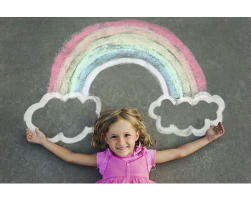 Dieťa leží pod dúhou a mrakmi nakreslenými kriedou