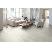 Svetlá obývacia izba s laminátovou podlahou s dreveným vzhľadom, pohovkou, kreslom a dreveným stolom