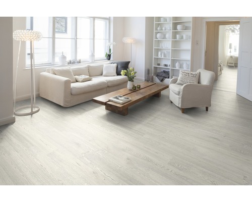 Svetlá obývacia izba s laminátovou podlahou s dreveným vzhľadom, pohovkou, kreslom a dreveným stolom