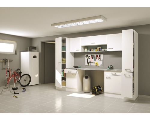 Dielňa s pracovným stolom, stenou na náradie, vysokými skriňami a bicyklom