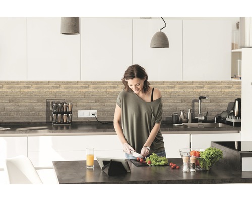 Moderná kuchyňa s drevenými panelmi a žena krájajúca zeleninu