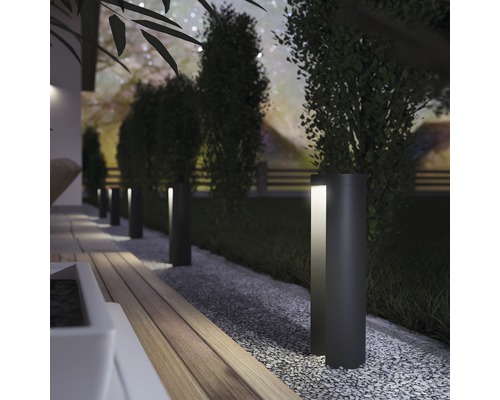 Záhradná cesta s niekoľkými kovovými stĺpikmi na osvetlenie cesty.