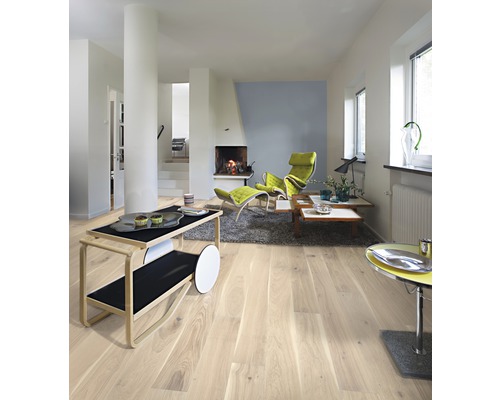 Svetlá obývacia izba s drevenou podlahou, krbom a moderným nábytkom.